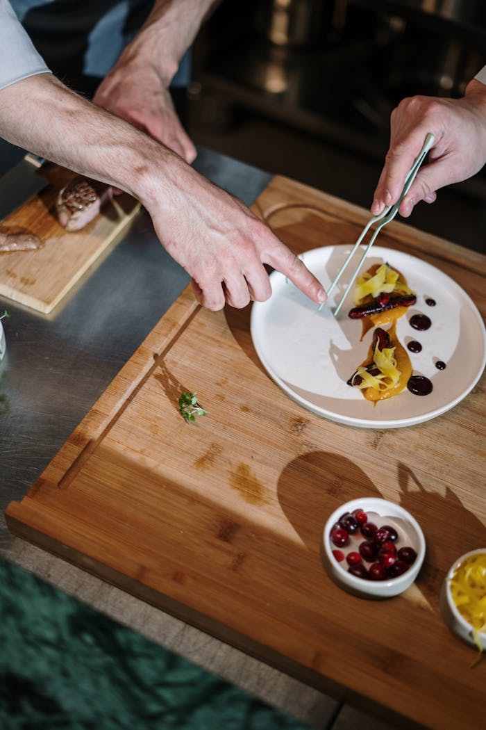 portfolio-01 A chef expertly plating a gourmet dish in an upscale kitchen setting.